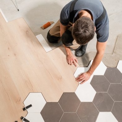 Flooring installer combining ceramic and wood flooring in a modern pattern